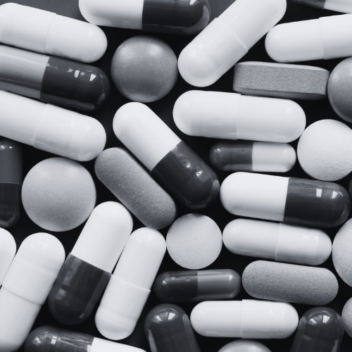 A collection of different pills on a table in black and white